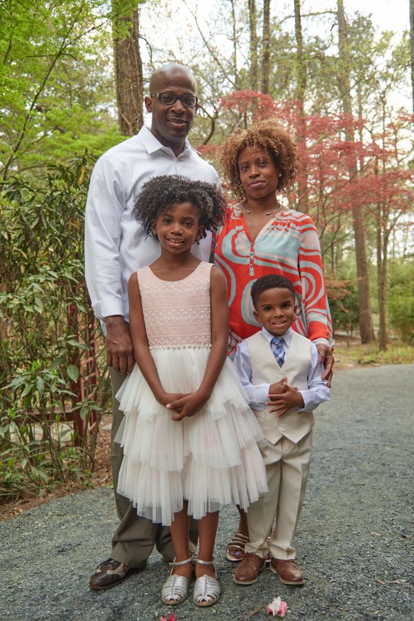 The family of four, close together, vertical portrait.