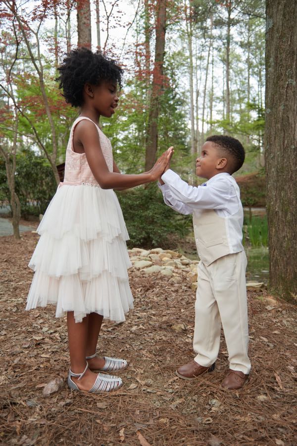 The two children reaching for each other's hands.