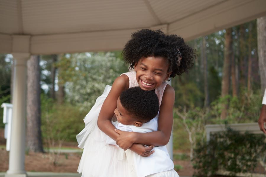 The two children in a tight hug, both laughing.