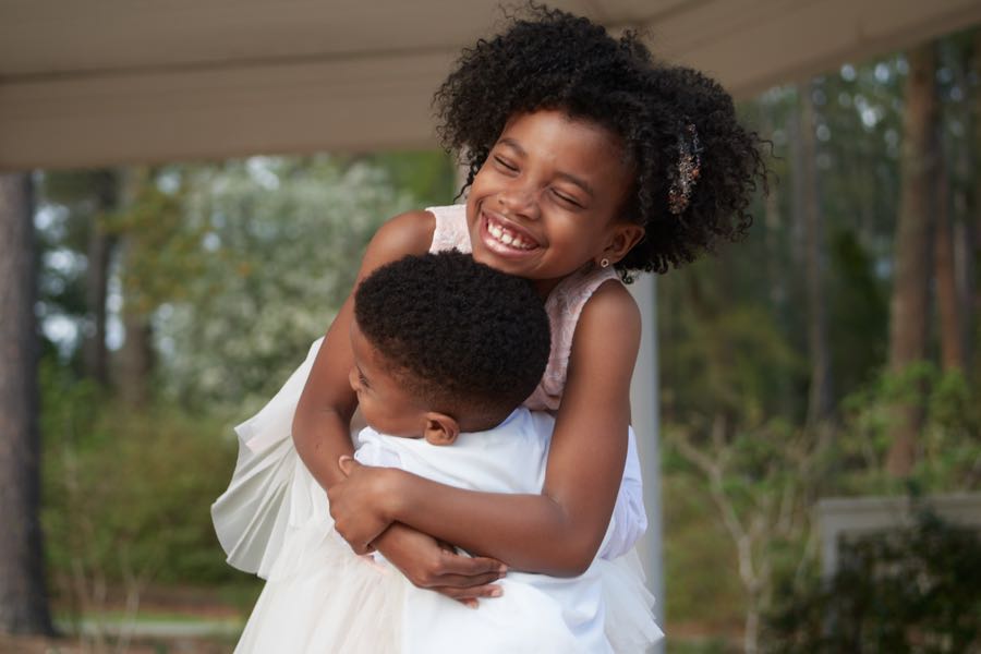 The two children hugging, close crop.