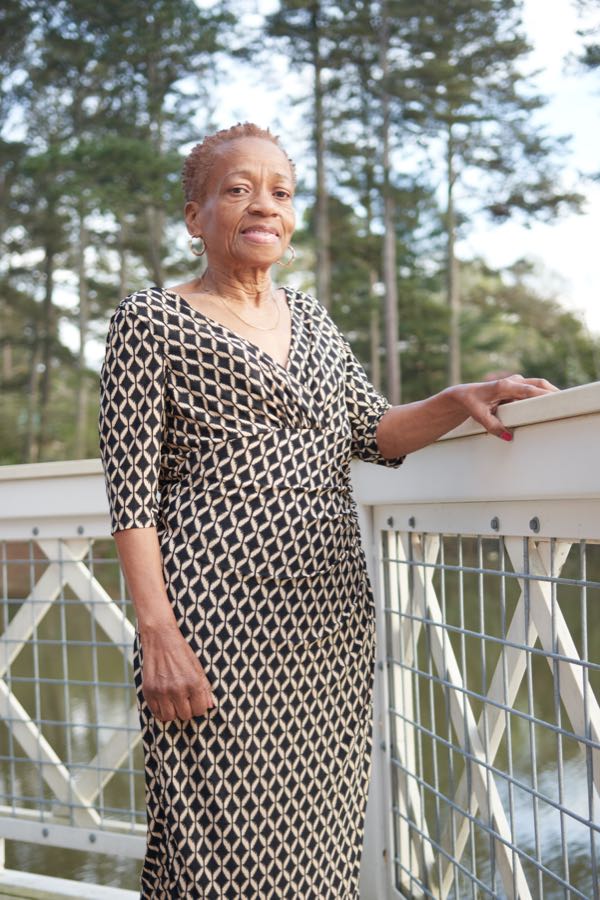 The grandmother standing at a white railing.
