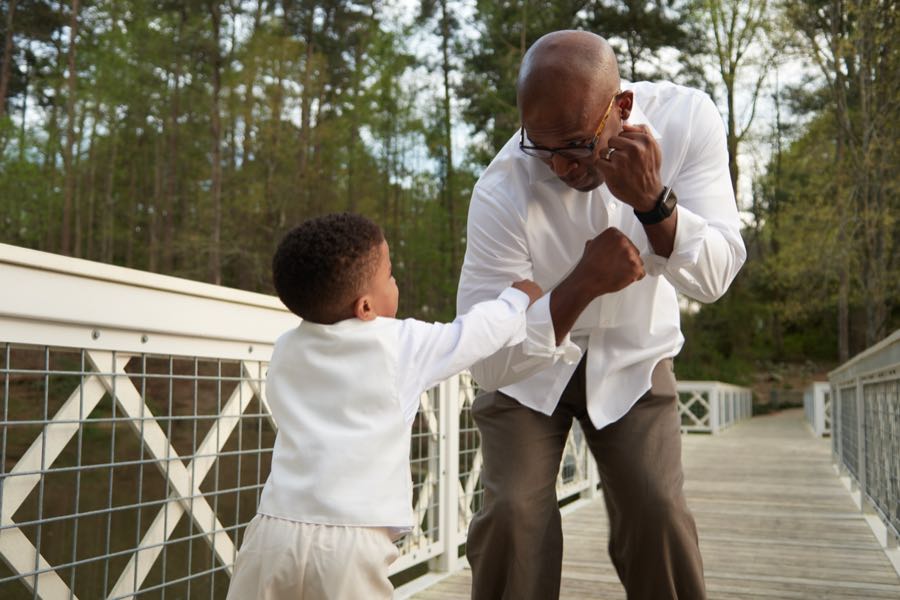 A boy and his grandfather squaring up, playing at boxing.