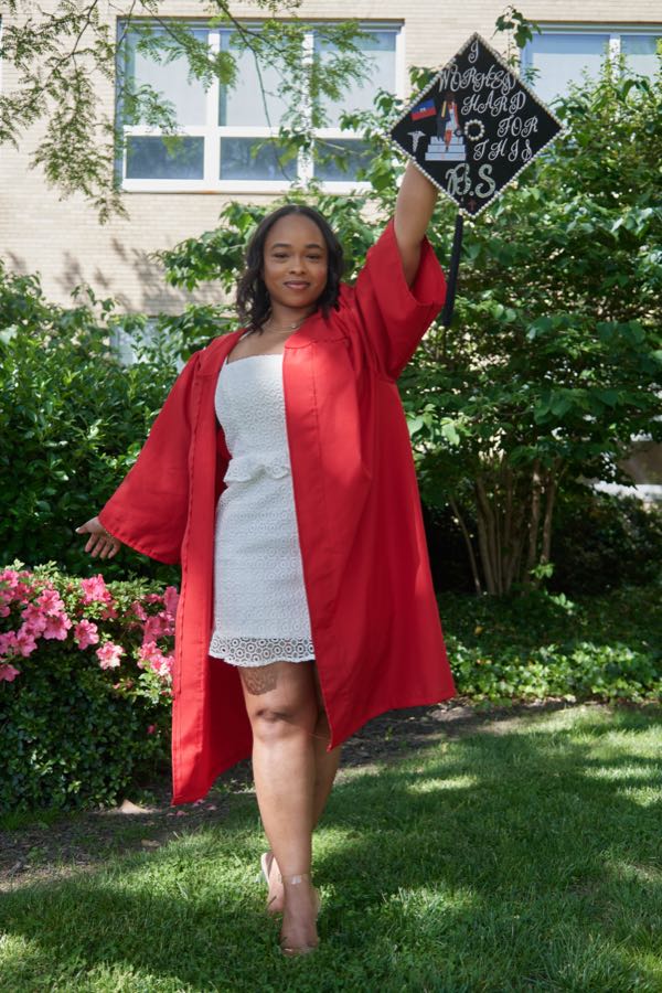 Raising the graduation cap overhead in a garden.