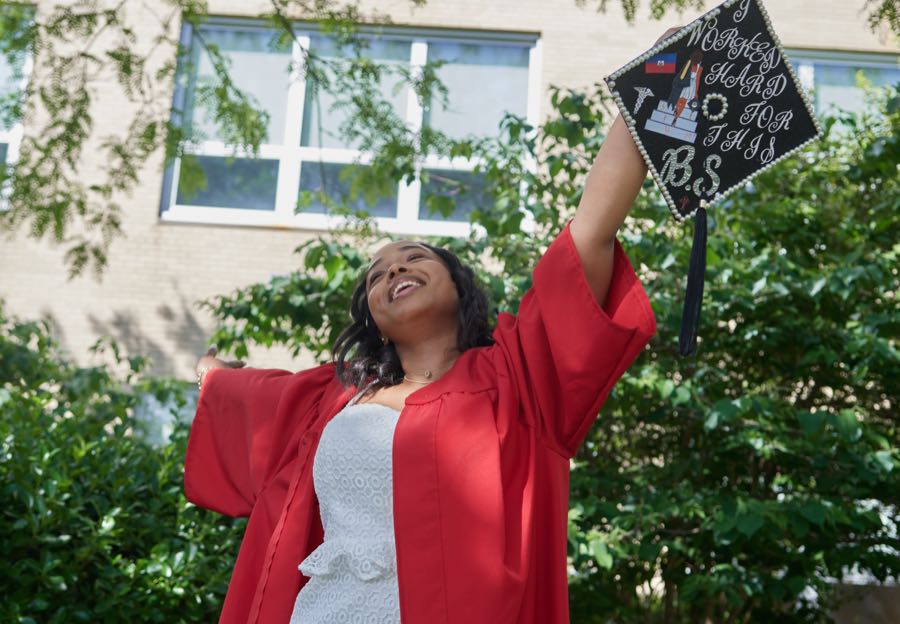 Raising the decorated cap, arm extended.