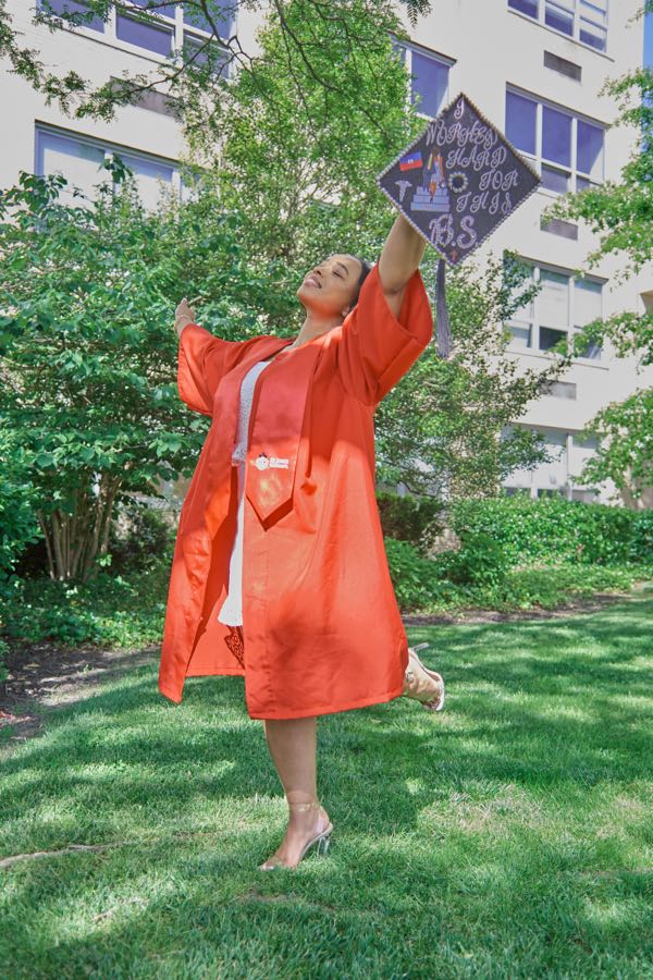 Spinning in the gown, arms out, cap in hand.