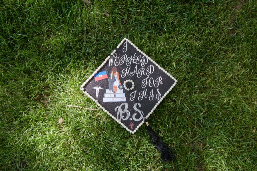 The decorated graduation cap laid on the grass.