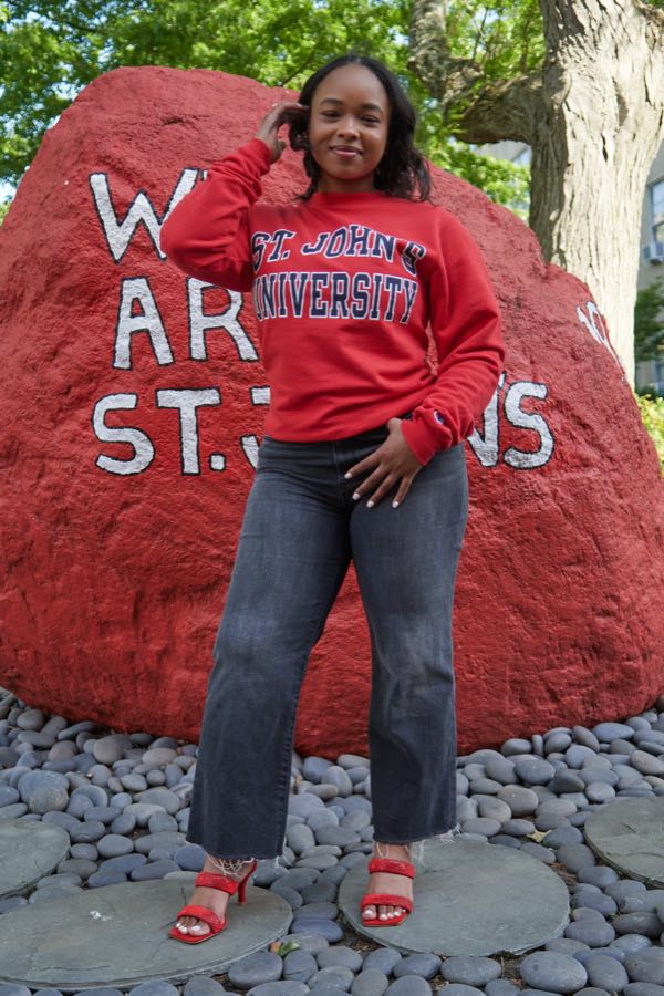 Full length at the campus rock, hands on hips.