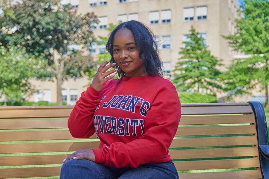 Seated on a campus bench in the university sweatshirt.